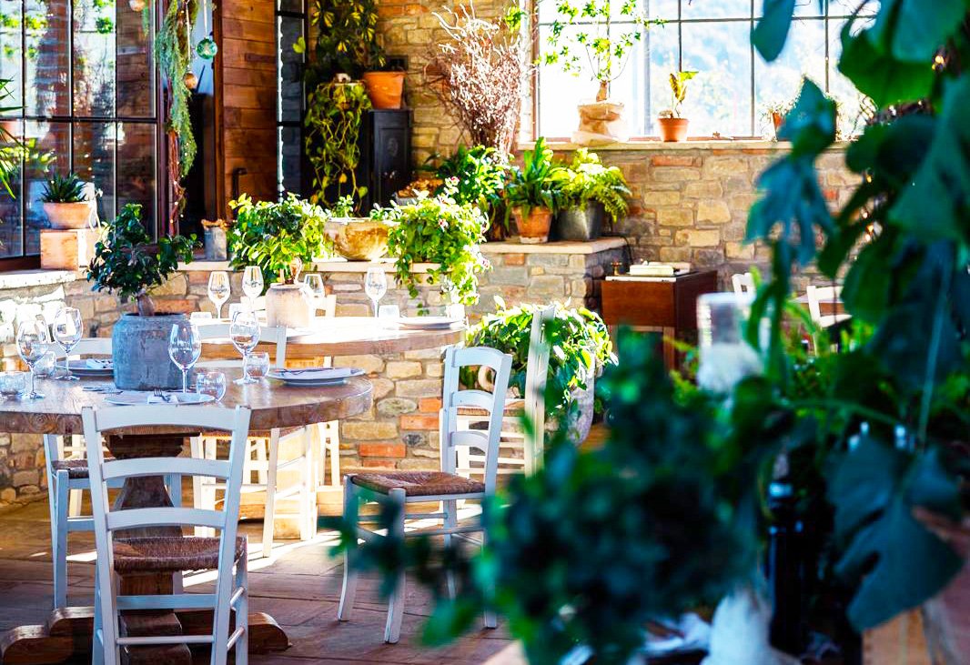Il Giardino d'Inverno con le ampie vetrate e i tavoli apparecchiati